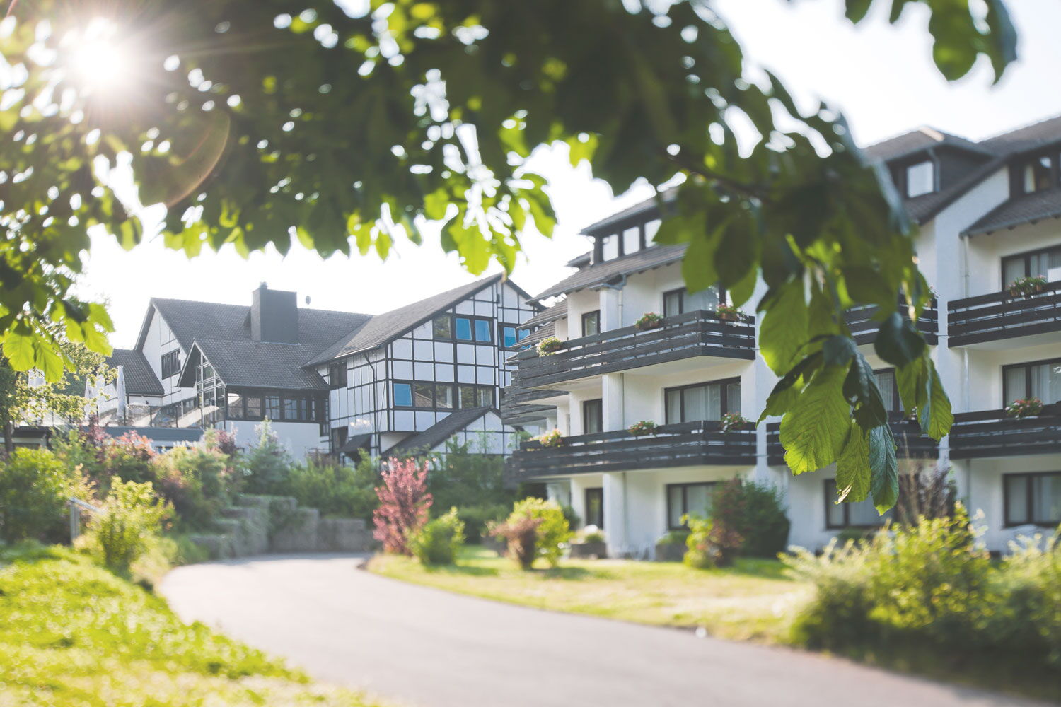 Haupthaus des Sporthotel Grafenwald in grüner Umgebung