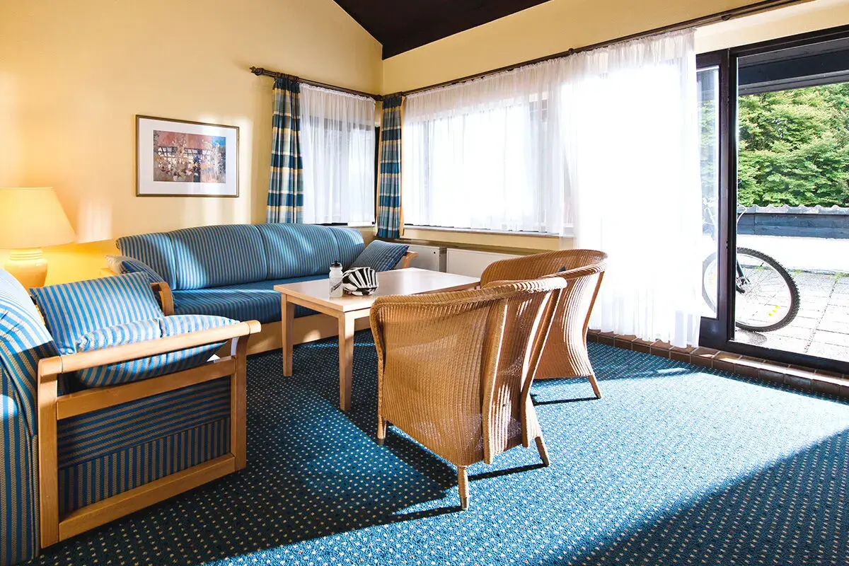 Heller Wohnzimmerbereich des Ferienhaus Ahorn mit Blick auf die Terrasse