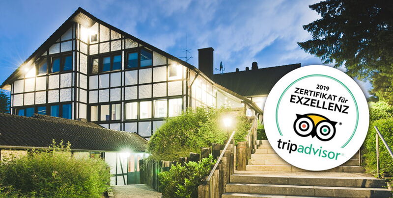 Das Hauptgebäude des Sporthotel Grafenwald im Dunklen mit toller Beleuchtung und das Trip Advisor Zertifikat für Exzellenz