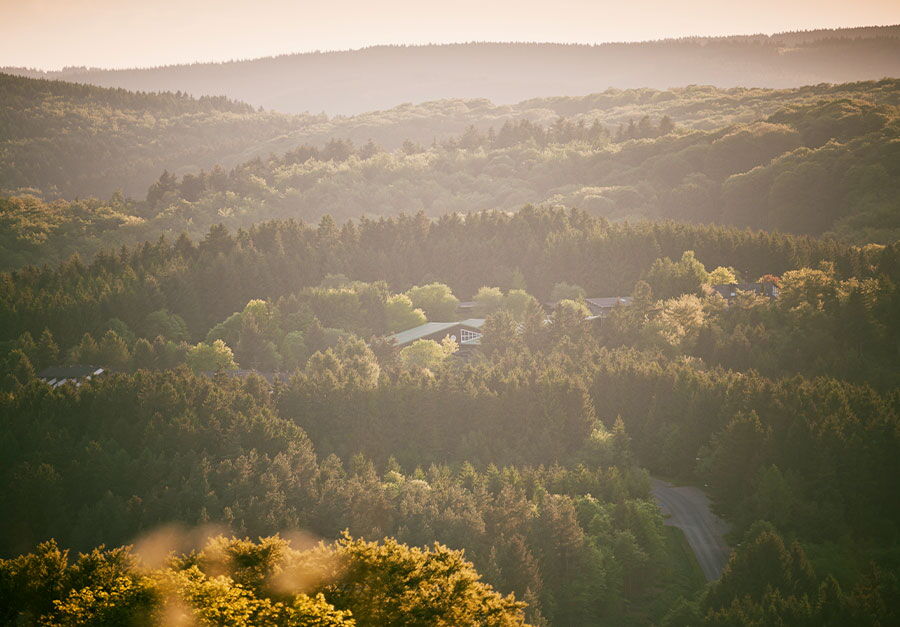 Blick über die Wälder der Vulkaneifel und die Hotelanlage des Sporthotel Grafenwald