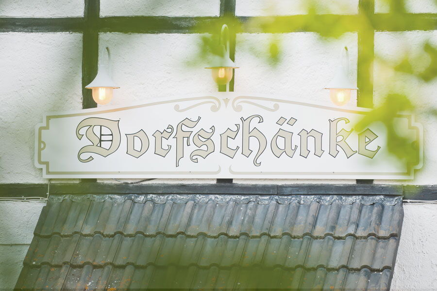 Schild Dorfschänke an der Fassade des Sporthotel Grafenwald