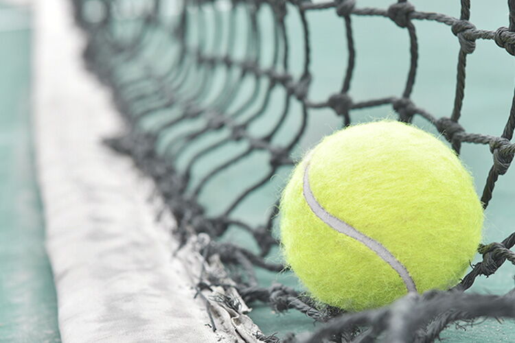Tennisball liegt auf Netz auf dem Tennisplatz im Sporthotel Grafenwald