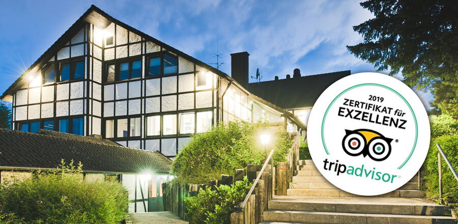 Das Hauptgebäude des Sporthotel Grafenwald im Dunklen mit toller Beleuchtung und das Trip Advisor Zertifikat für Exzellenz